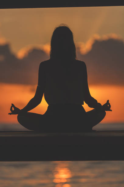istock Woman practicing yoga on the beach. 693279940