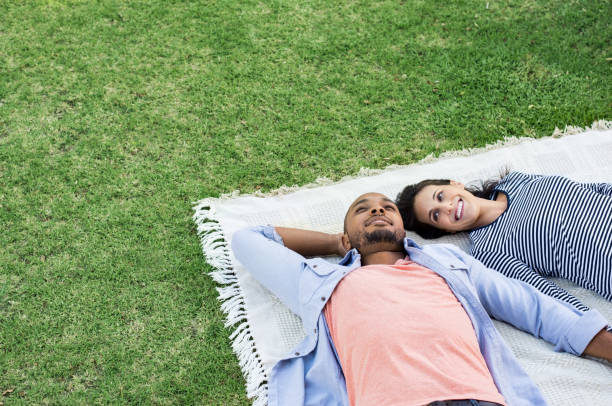 Couple lying on blanket at park