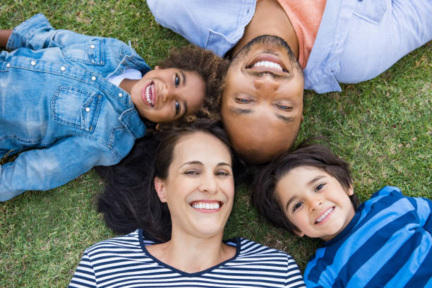 famille allongé sur l'herbe - family with two children family park child photos et images de collection