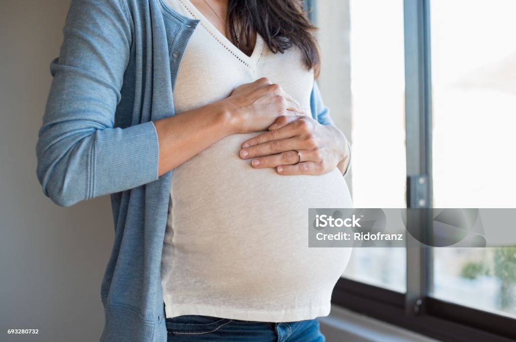 Closeup belly of pregnant woman Close up of pregnant woman touching her belly. Lovely young woman expecting a baby. Pregnant woman hugging her tummy. Pregnant Stock Photo