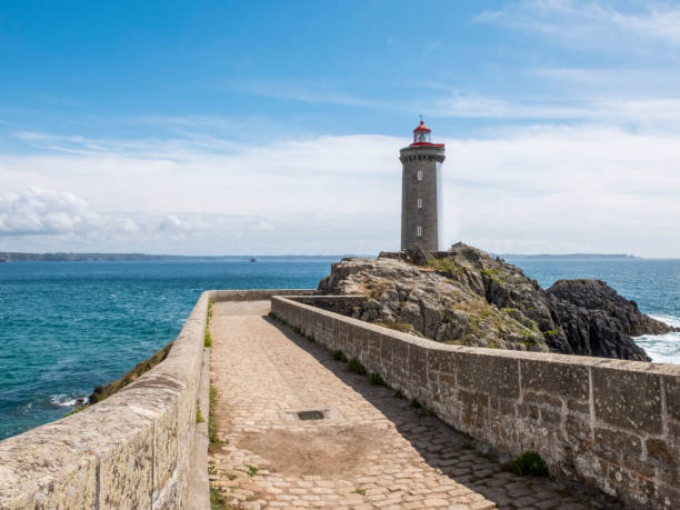 istock Ancient stone pier with lighthouse on the rocks 693293606