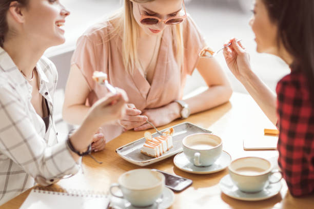 istock young girls eating cake and drinking coffee at cafe, coffee break 693294294