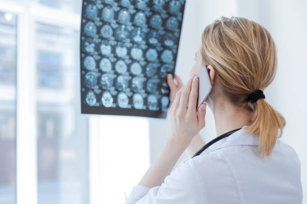 abile medico che discute di radiografia cerebrale in clinica - mri scan cat scan machine x ray brain foto e immagini stock