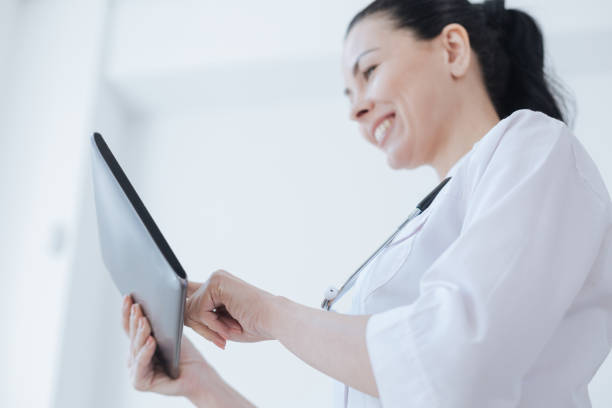 istock Cheerful therapist using tablet for work in the clinic 693306526