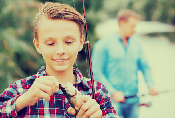 istock Teenager boy looking at fish on hook 693306748