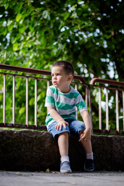 istock Cute Little Boy Sitting On Quayside 693306844