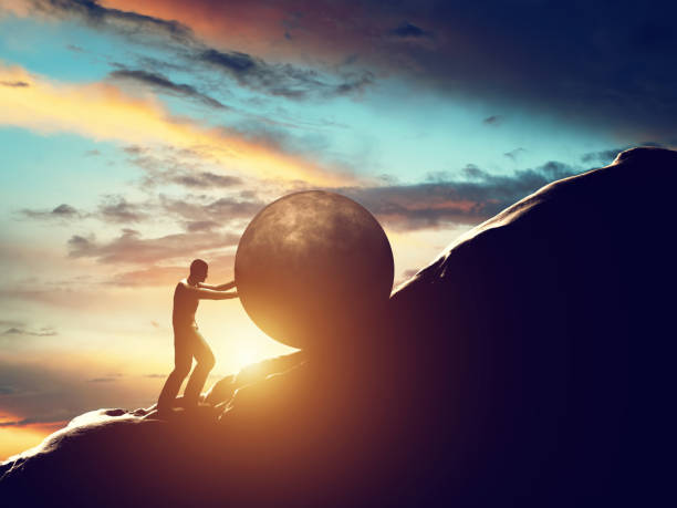 sisyphus metaphor. man rolling huge concrete ball up hill. - colina acima imagens e fotografias de stock