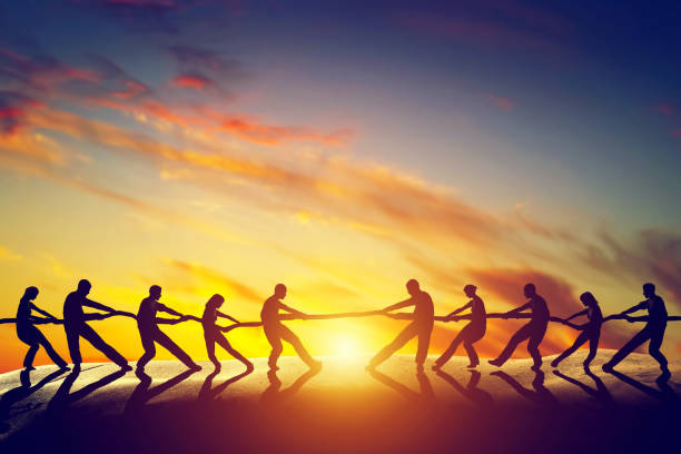 Two groups of people pulling line, playing tug of war. Two groups of people pulling line, playing tug of war. Competition, teamwork, strength. Conceptual business battle stock pictures, royalty-free photos & images