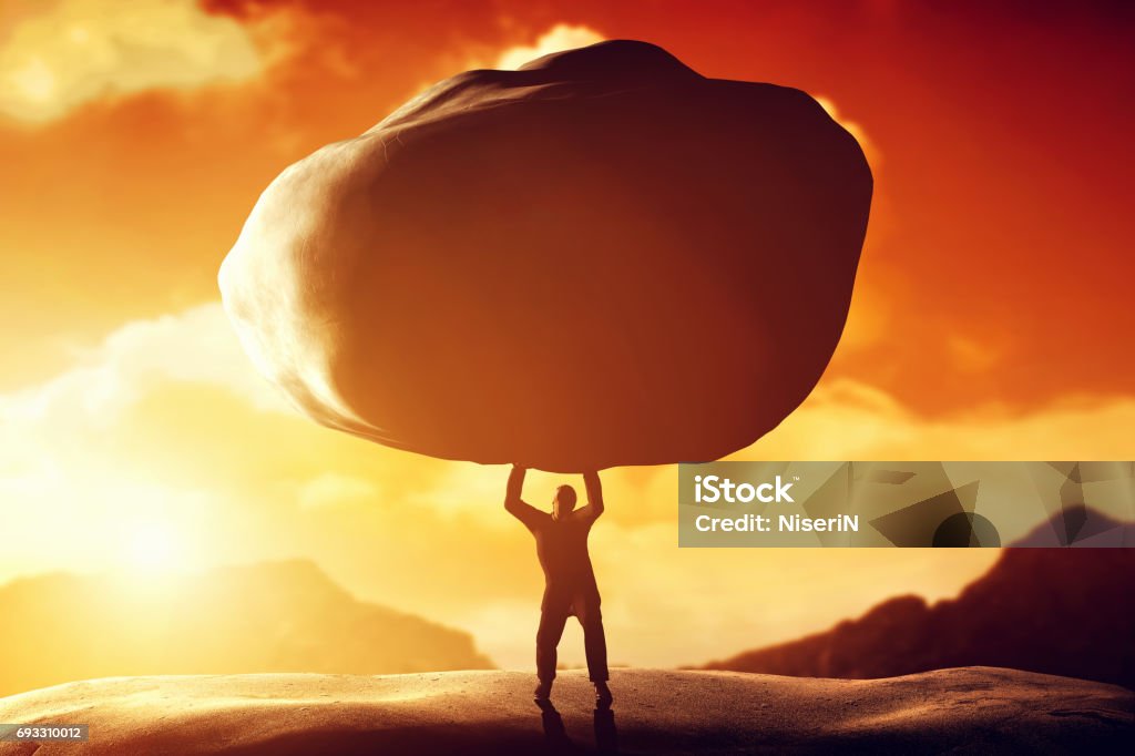 Man lifting a huge rock. Concept of strength, ballast, difficulty, power Man lifting a huge rock. Metaphor, concept of strength, burden, ballast, power etc. Picking Up Stock Photo