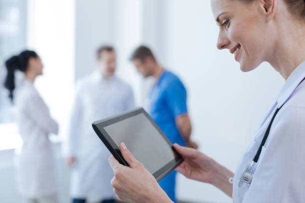 istock Cheerful nurse using digital device in the clinic 693310992