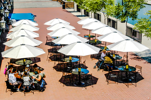 People snacking under Silver umbrellas at a cafe in the Canal District of Indianapolis, IN