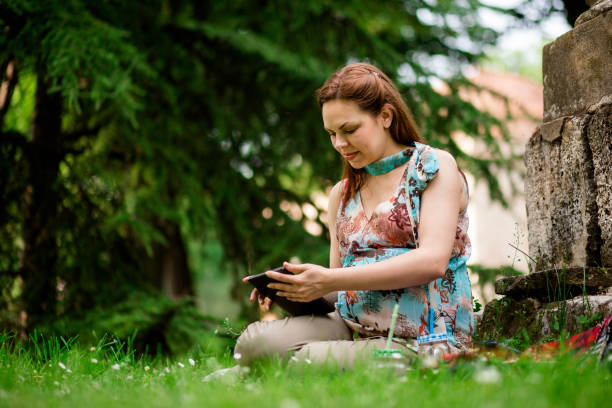 istock Pretty Young Pregnant Woman Using Digital Tablet Outdoor 693313828