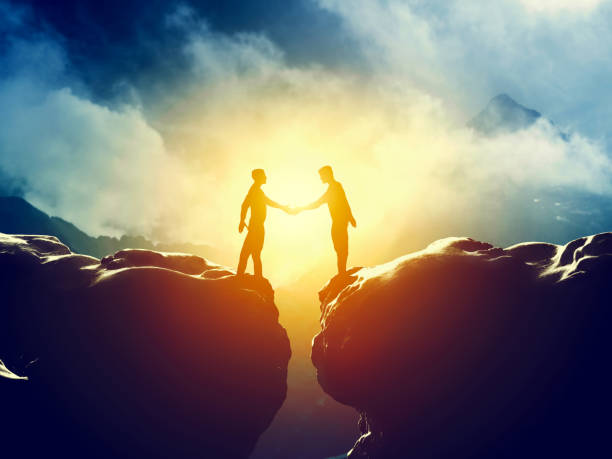 istock Two men handshake over mountains precipice. Business deal 693314398
