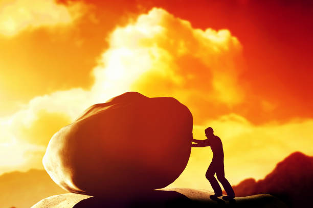istock Man pushing a giant, heavy stone, rock over the mountain. 693314406