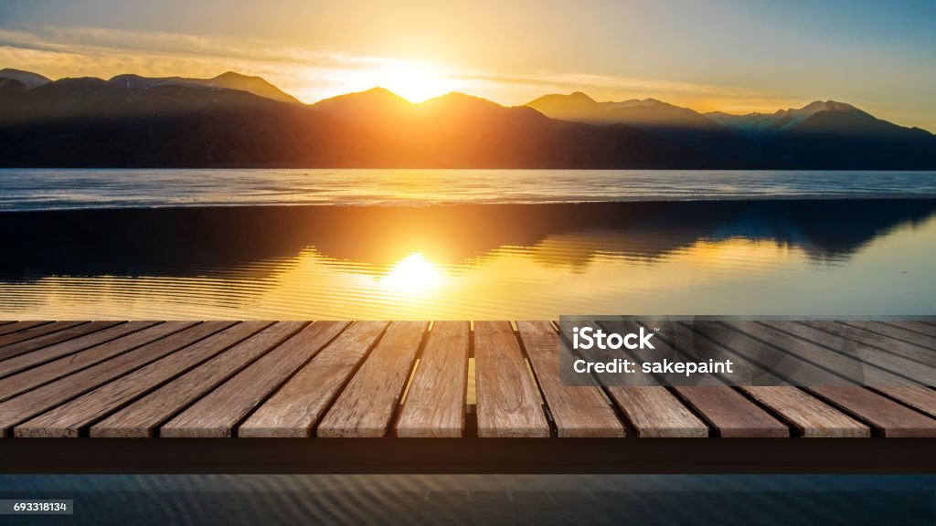 Holzbrücke am See mit einer Reflexion der Sonnenuntergang auf dem Schneeberg - Lizenzfrei Sonnenuntergang Stock-Foto