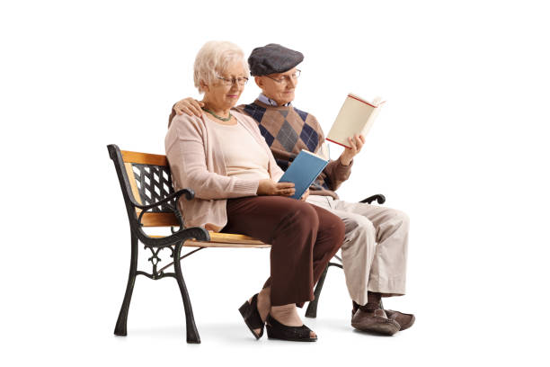 istock Mature couple sitting on a bench and reading books 693319574