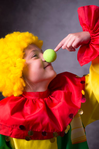 istock child clown touches nose 693332286