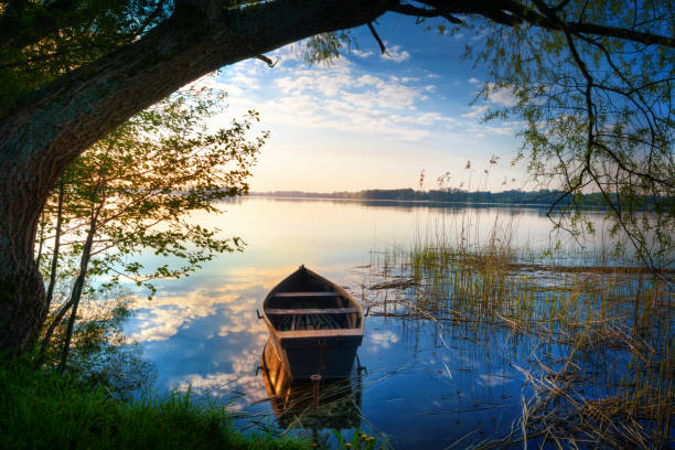 Selment Wielki wooden boat 2 Rowing boat floating over the Lake Selment Wielki waters. Masuria, Poland. rowing boat fishing stock pictures, royalty-free photos & images
