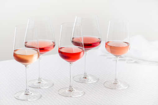 Grouping of five varieties of rose wine in wineglasses.