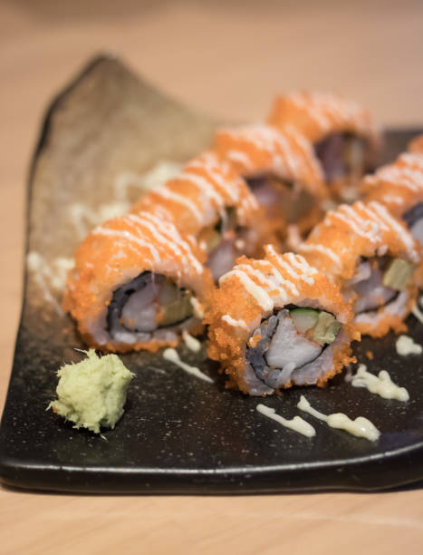 istock close up of sushi rolls on black plate 693340312