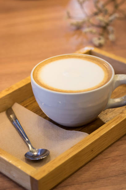 istock Cappuccino coffee in white cup on wooden table. 693344878