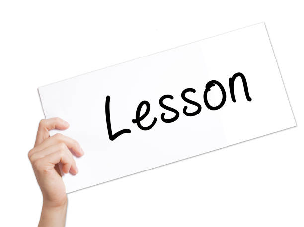 Lesson Sign on white paper. Man Hand Holding Paper with text. Isolated on white background