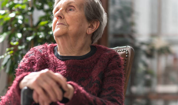 istock Old woman with her hands on a cane 693360456
