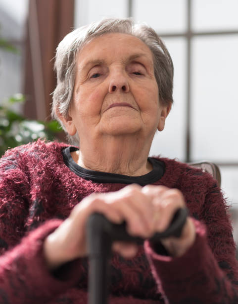 istock Old woman with her hands on a cane 693360464