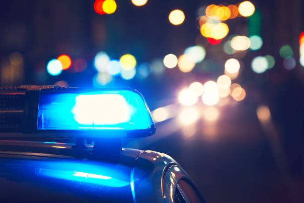 Police car on the street Danger on the road. Blue flasher on the police car at night. law enforcement and crime stock pictures, royalty-free photos & images