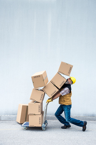 Delivery man with falling stack of boxes