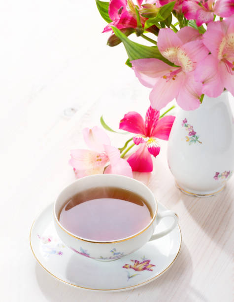 Retro still life with  cup of tea and flowers (Alstroemeria)