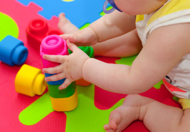 istock Toddler plays with building block 693363798