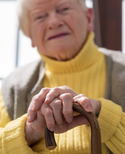istock Old woman with her hands on a cane 693363838