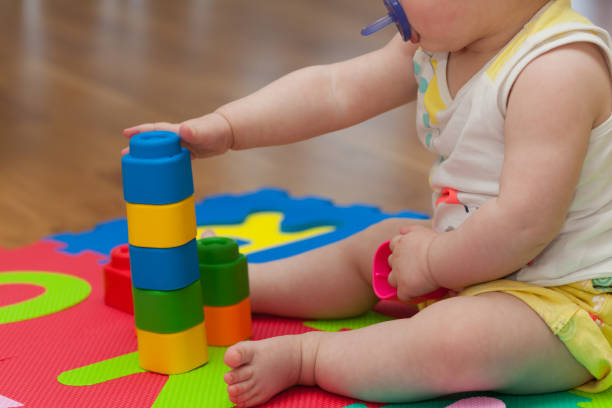 istock Toddler plays with building block 693366328