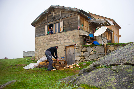 people living at plateau and man cut wood, prepare snall woods for the stove. Rize, Turkey. August 18, 2012