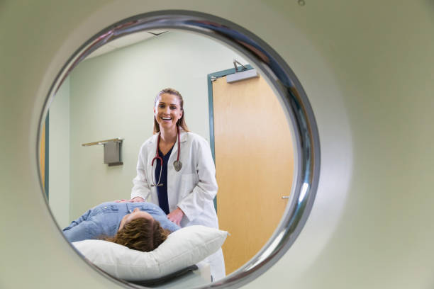 istock Female doctor preparing patient for CT scan 693370612