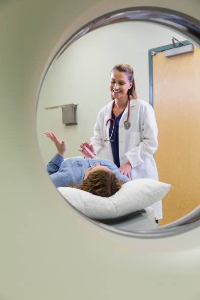 istock Female doctor preparing patient for CT scan 693370674