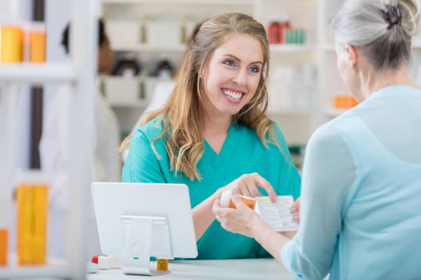 istock Young pharmacist talks with senior female customer 693377356