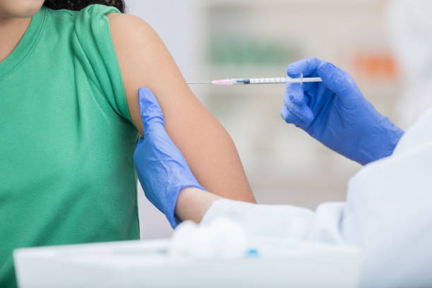 인식할 수 없는 여자는 독감 예방 주사를 받습니다. - syringe injecting vaccination cold and flu 뉴스 사진 이미지