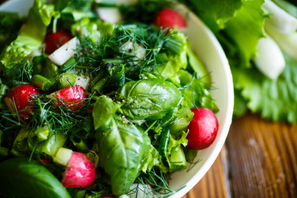 spring salad from early vegetables, lettuce leaves, radishes and herbs - leafy green vegetables imagens e fotografias de stock