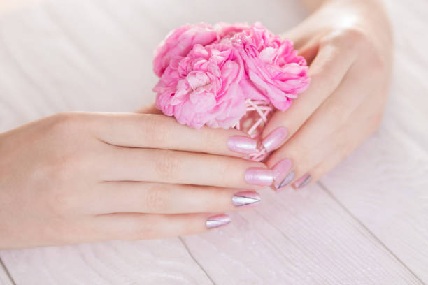 istock Beautiful pink manicure with silver triangles 693396614