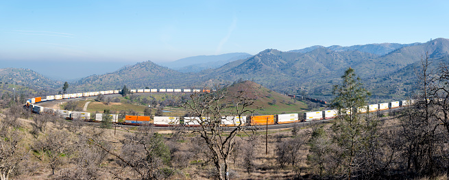 Tehachapi, California USA -March 11,2017:Row of freight trains pass through famous Tehachapi Loop in Kern County South Central California  USA.  The Tehachapi Loop is a long spiral on the railroad main line through Tehachapi Pass located in Kern County  Califronia  USA. It is at 4000 Ft above the sea level