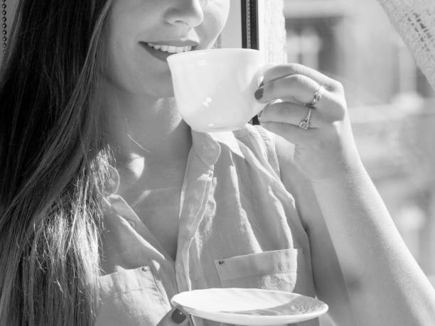 istock Woman looking through window, relaxing drinking coffee 693416182