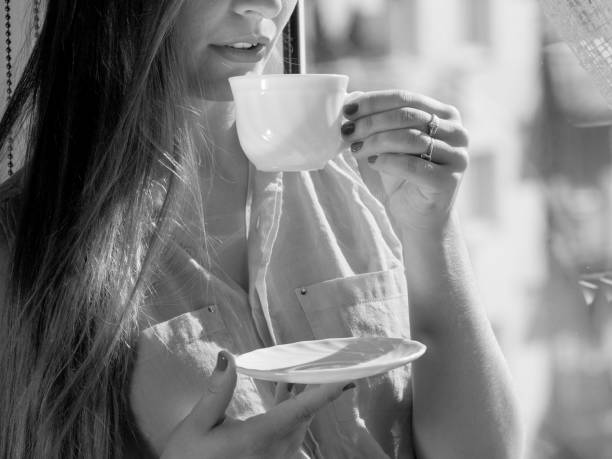 istock Woman looking through window, relaxing drinking coffee 693416844