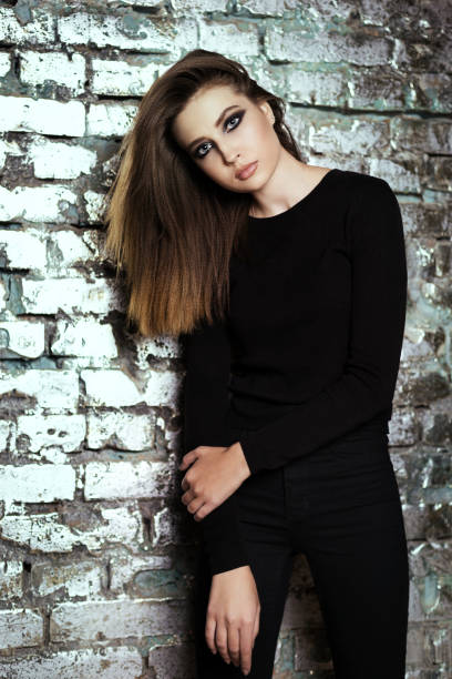 istock girl in black posing at a brick wall 693425908