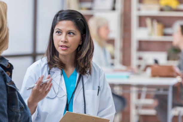 istock Confident Asian physician talks with female patient 693429136