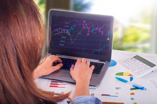istock Young woman working on laptop, trading 693433618
