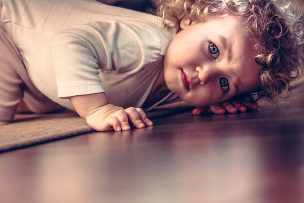 istock Scared child hiding under the bed in kid room and looking scared 693439544