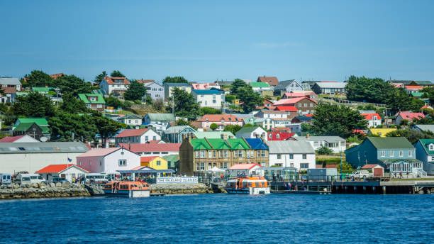 coloridas casas dominan el paisaje árido de las islas malvinas - islas malvinas fotografías e imágenes de stock