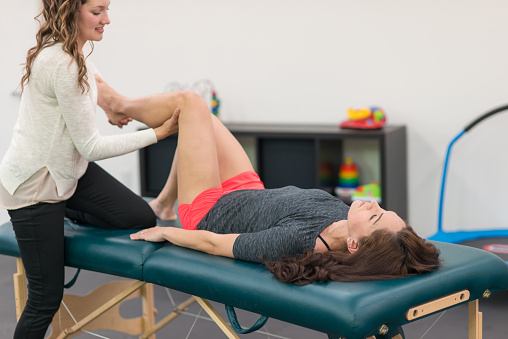 Physical therapist doing stretches with female patient